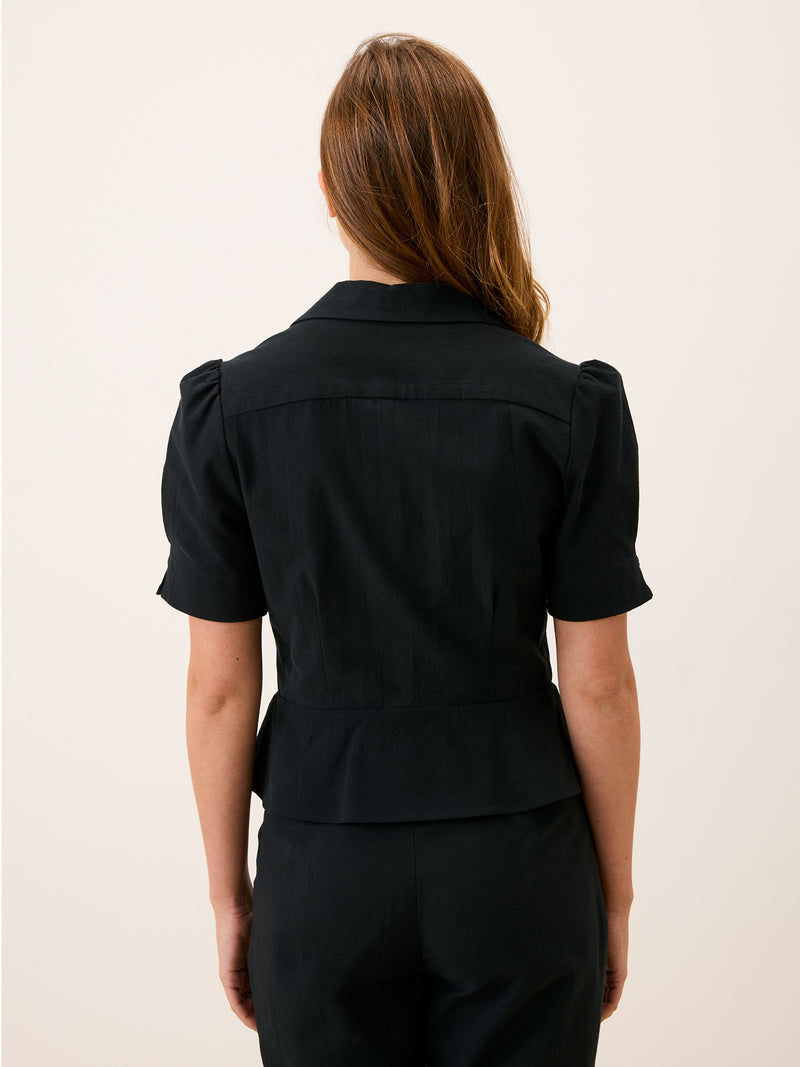 ANISA black cotton peplum blouse, detail of V-neck by Rouje